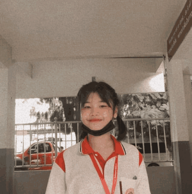 a girl wearing a red and white uniform and a black face mask