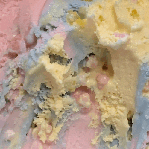 a close up of a rainbow colored ice cream with bubbles in it