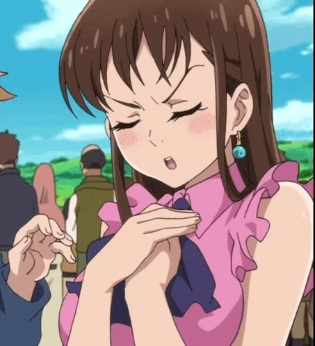 a close up of a girl with her eyes closed wearing a pink top and blue earrings