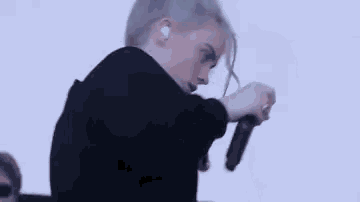 a close up of a person holding a microphone while wearing headphones .