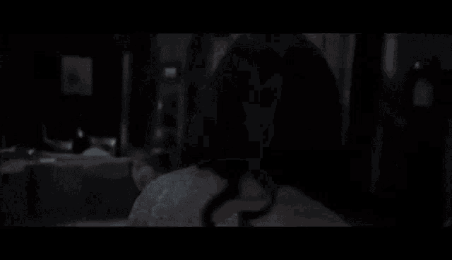 a close up of a person 's face in a dark room with a blurred background .