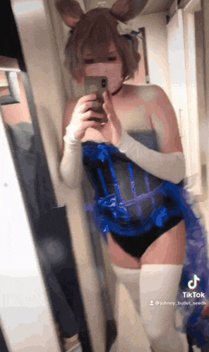 a woman is taking a picture of herself in front of a mirror with tiktok written on the bottom right