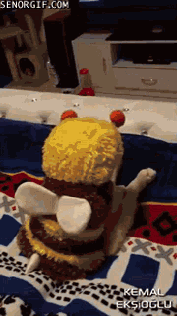 a cat wearing a bee costume is laying on a bed