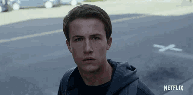 a young man standing in front of a netflix logo