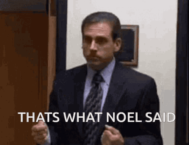 a man in a suit and tie is standing in front of a door and says `` thats what noel said '' .