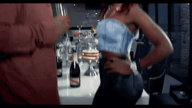 a woman is standing in front of a counter with bottles of champagne on it .