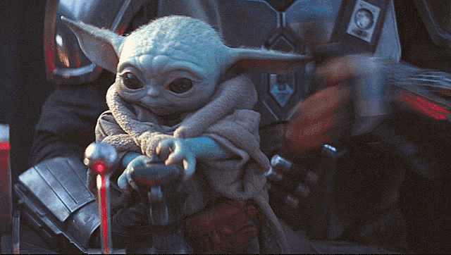 a baby yoda is being held by a soldier