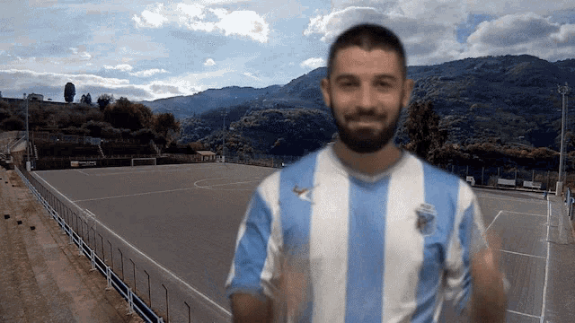a man with a beard wearing a blue and white striped shirt
