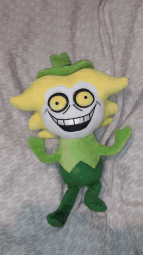 a yellow and green stuffed animal with a green hat