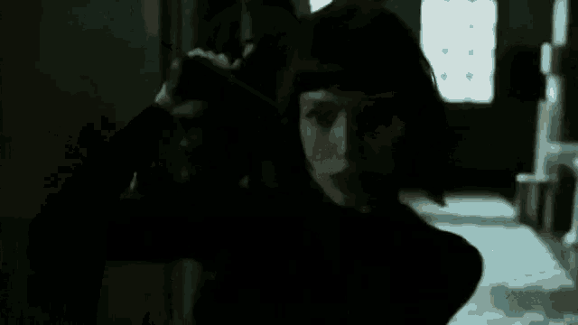 a woman is walking down a hallway holding a gun .
