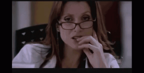 a close up of a woman wearing glasses and a white lab coat .