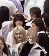a group of people are standing in a crowd of people and talking to each other .