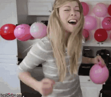 a woman is holding a pink balloon that says " i love you " on it