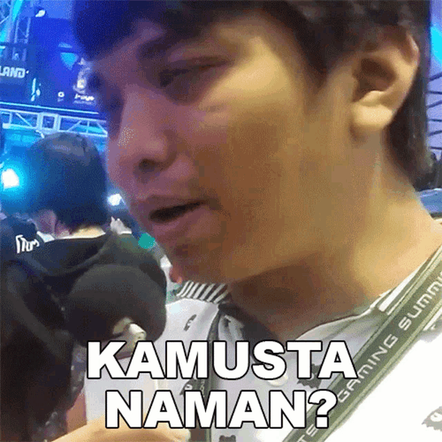 a man wearing a lanyard that says kamusta naman on it