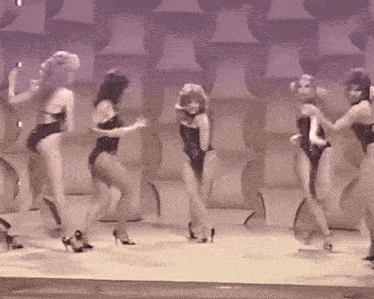 a group of women in swimsuits are dancing on stage