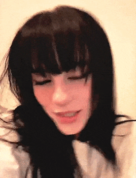 a close up of a woman with long black hair and bangs .