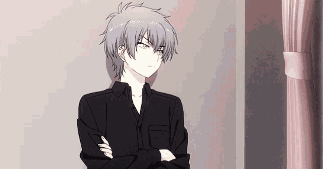 a man with gray hair is standing with his arms crossed