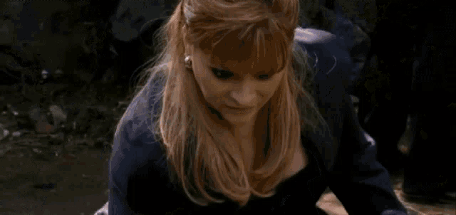 a woman in a blue dress is smiling and looking at the camera .