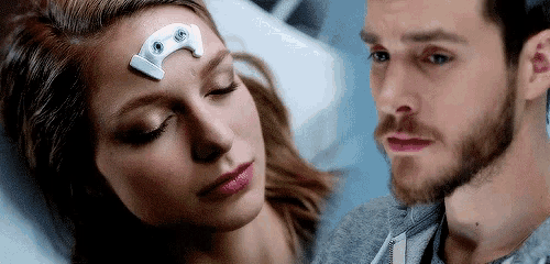a man and a woman are looking at each other in a hospital bed .