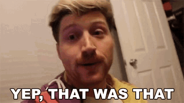 a man with a beard is standing in front of a door with the words yep that was that written on his face .