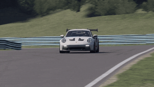 a white porsche gt3 rs is driving down a track