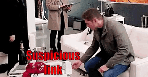 a man is sitting on a couch in a living room with the words suspicious link behind him .