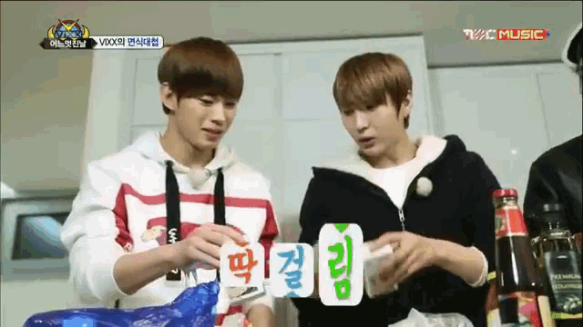 a group of young men are playing a game of cards and one of them is wearing a hoodie with the word vixx on it