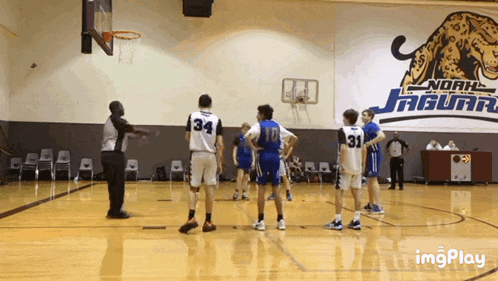 a basketball game being played in front of a noah jaguars banner