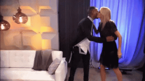 a man and a woman kissing in a living room