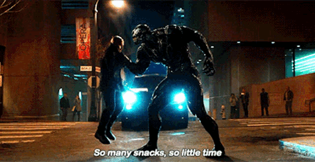 a man in a black suit is standing next to a venom .