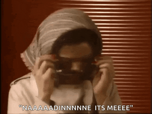 a man wearing a scarf around his head and sunglasses says " naaaadinnnne its meeeee "
