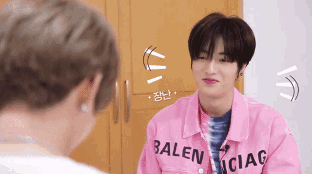 a man wearing a pink jacket that says balenciag on it