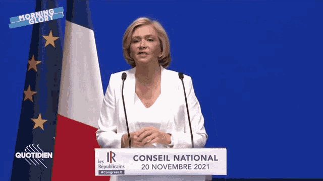 a woman stands at a podium that says conseil national on it
