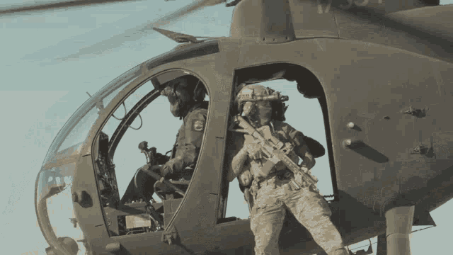 two soldiers in a helicopter with one wearing a helmet that says ' u.s. air force ' on it