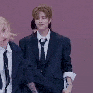 a man in a suit and tie is dancing with another man in a suit and tie .
