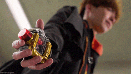 a man in a black jacket is holding a device in his hand .