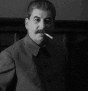 a black and white photo of a man with a mustache smoking a cigarette .