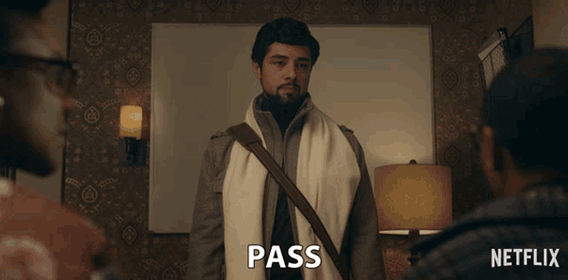 a man with a scarf around his neck is standing in front of a netflix sign