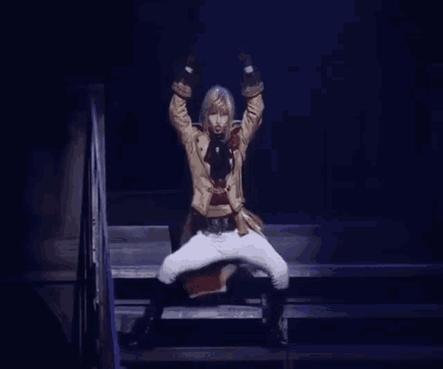a man in a costume is sitting on a set of stairs with his arms up in the air .
