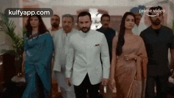 a group of people are standing next to each other in a room in a room .