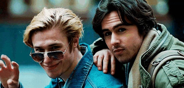 two men wearing sunglasses are posing for a picture together