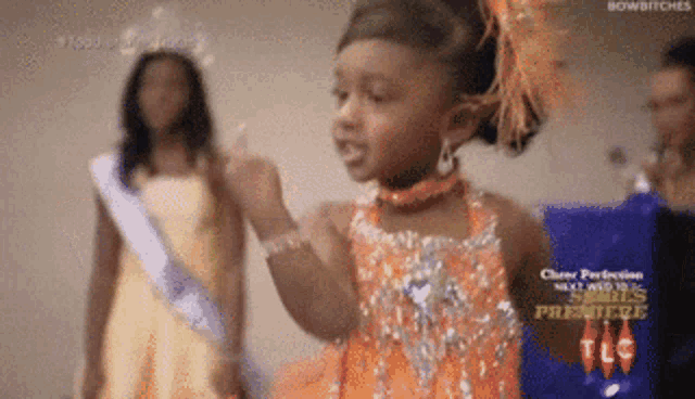 a little girl in a pageant dress is giving the middle finger