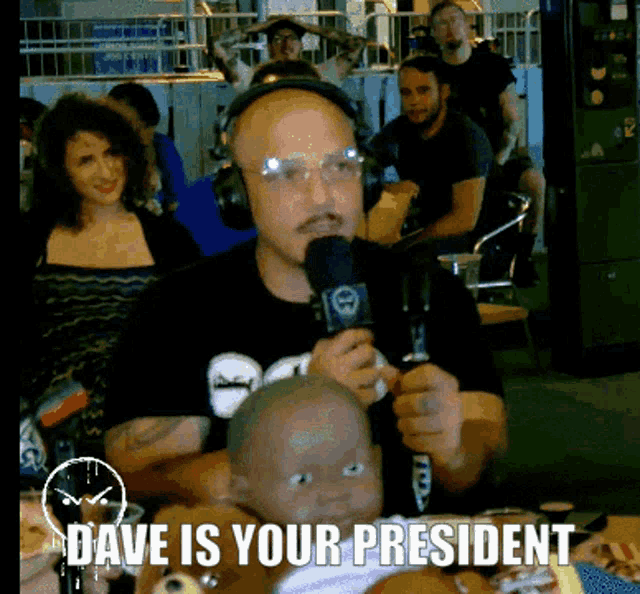 a man wearing headphones is holding a baby and says " dave is your president " on the bottom
