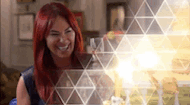 a woman with red hair is sitting in front of a glass of wine .