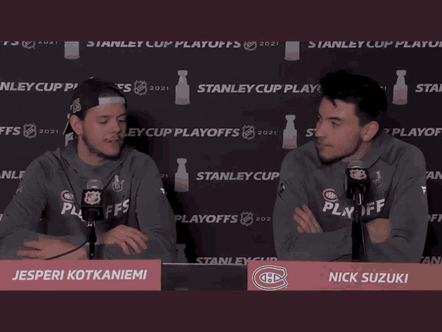 two men sitting in front of microphones with the name nick suzuki on the front