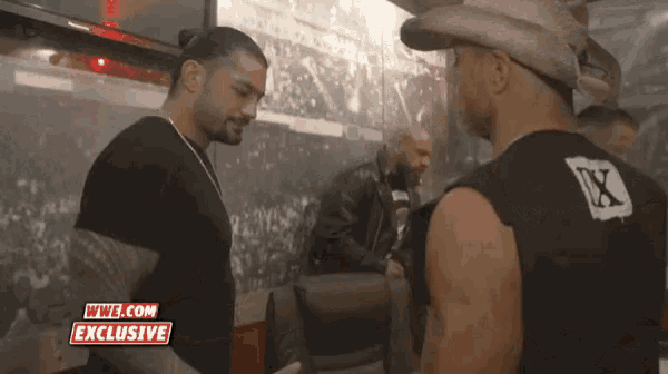 two men standing next to each other with a wwe.com exclusive advertisement in the corner