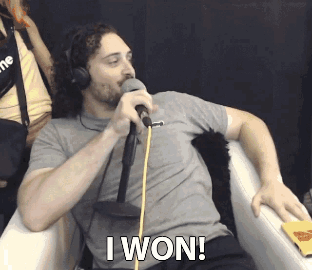 a man wearing headphones singing into a microphone with the words i won written below him