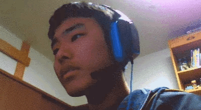 a man wearing headphones with a microphone looks at the camera