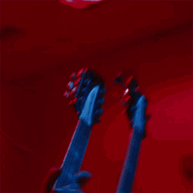 a close up of a person playing an electric guitar in a dark room