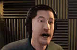 a man wearing headphones is making a funny face in a recording studio .